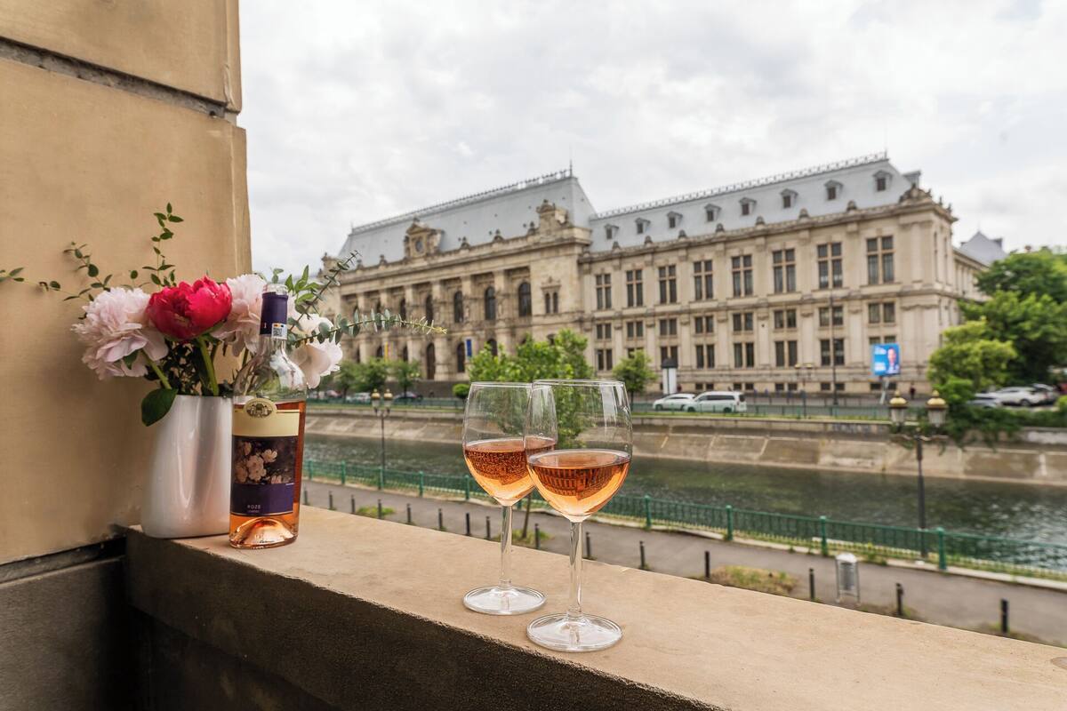 Un balcon avec vue sur un bâtiment historique et une rivière.