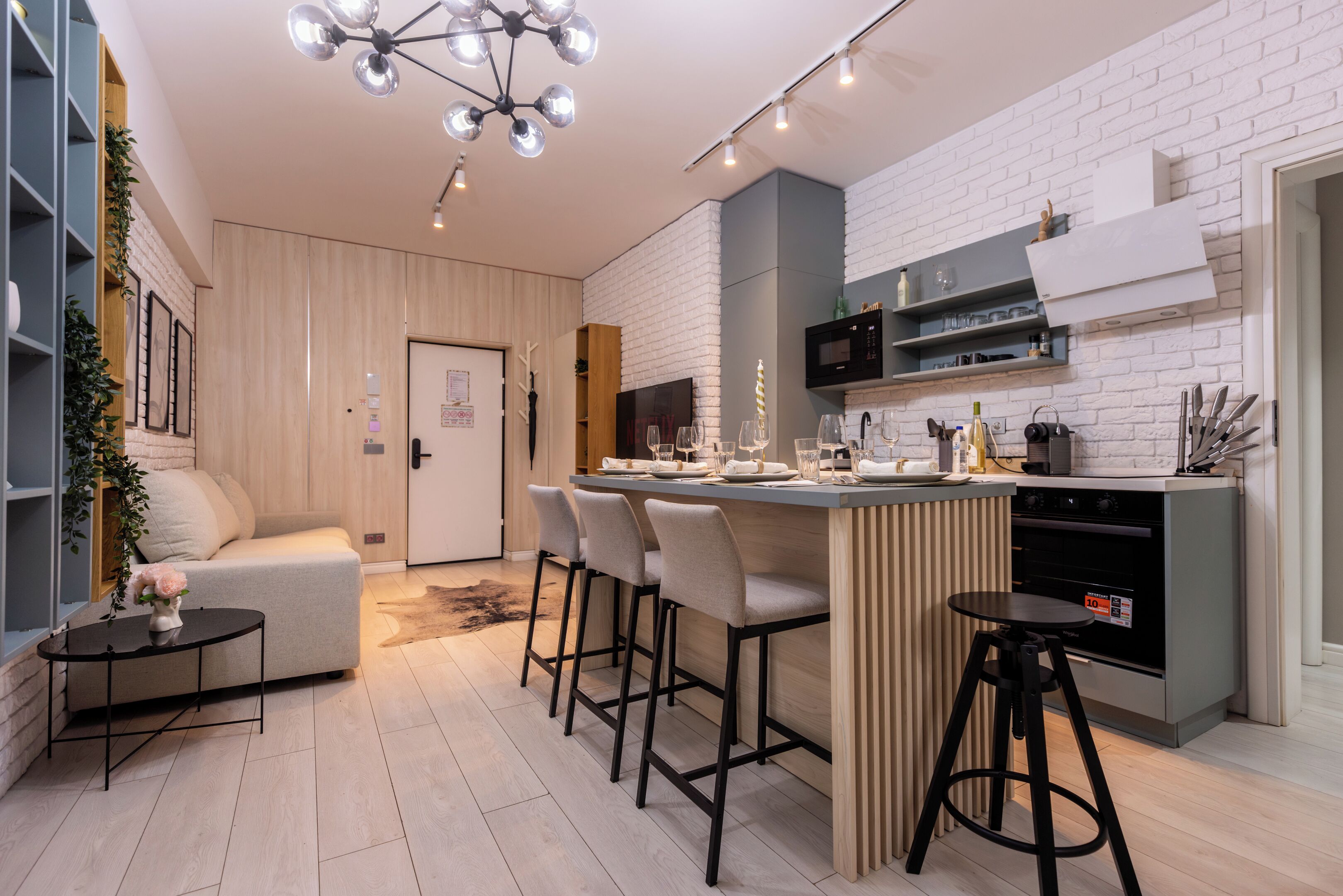 Una cocina moderna con una isla central, taburetes de bar, un microondas y un horno empotrado.