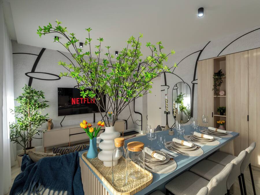 A modern dining area with a long table set for a meal, surrounded by potted plants and a television displaying 'NETFLIX'.
