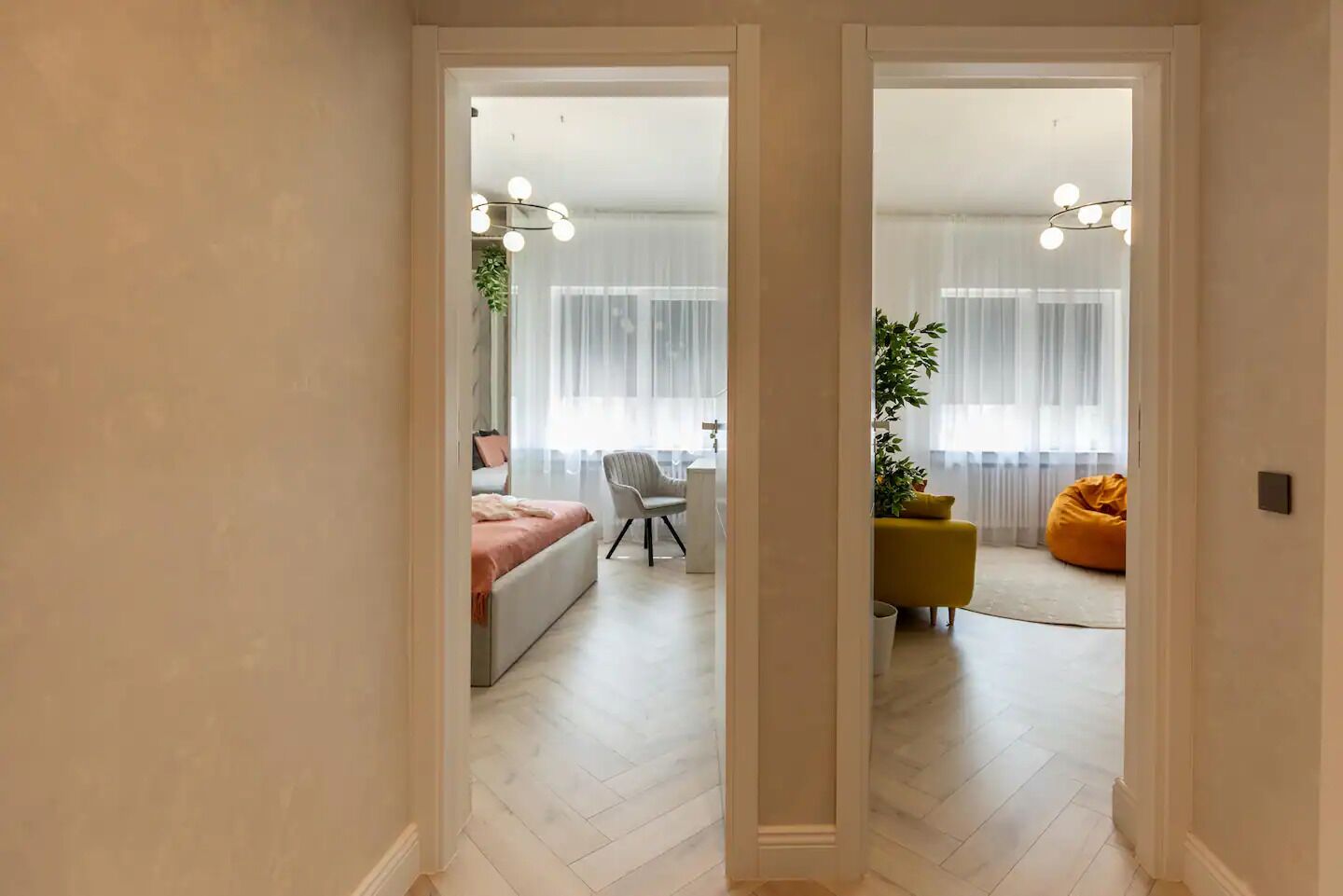 Un pasillo que conduce a un dormitorio con una cama, una silla y un sillón de peluche amarillo.