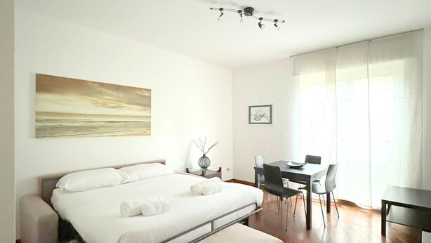 Una habitación de hotel moderna con cama, escritorio y zona de comedor.