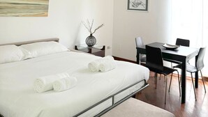 Una habitación de hotel moderna con una cama grande, un escritorio y una silla.