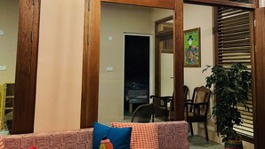 Un salon chaleureux avec un canapé, des coussins à motifs et un grand miroir.