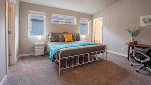 A bedroom with a bed, bedside tables, a desk, and a chair. - Boutique CDA Retreat | Sleeps 6 • Near Downtown (Coeur d'Alene)