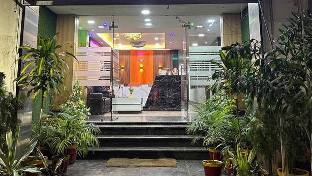 The entrance of Hotel Abinash with a reception desk, potted plants, and a check-in counter.