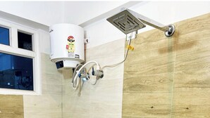 A bathroom with a toilet, a shower, and a sink.