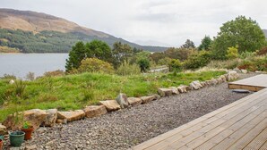 A deck with a view of a lake and mountains.