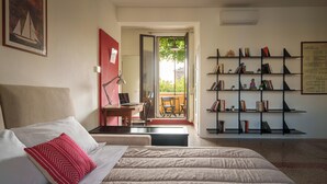 A bedroom with a bed, a desk, and a bookshelf. - Accomodo MIB13 Bivano Navigli (Milan)
