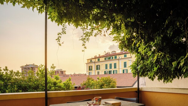 A balcony with a table, chairs, and an open book. - Accomodo MIB13 Bivano Navigli (Milan)