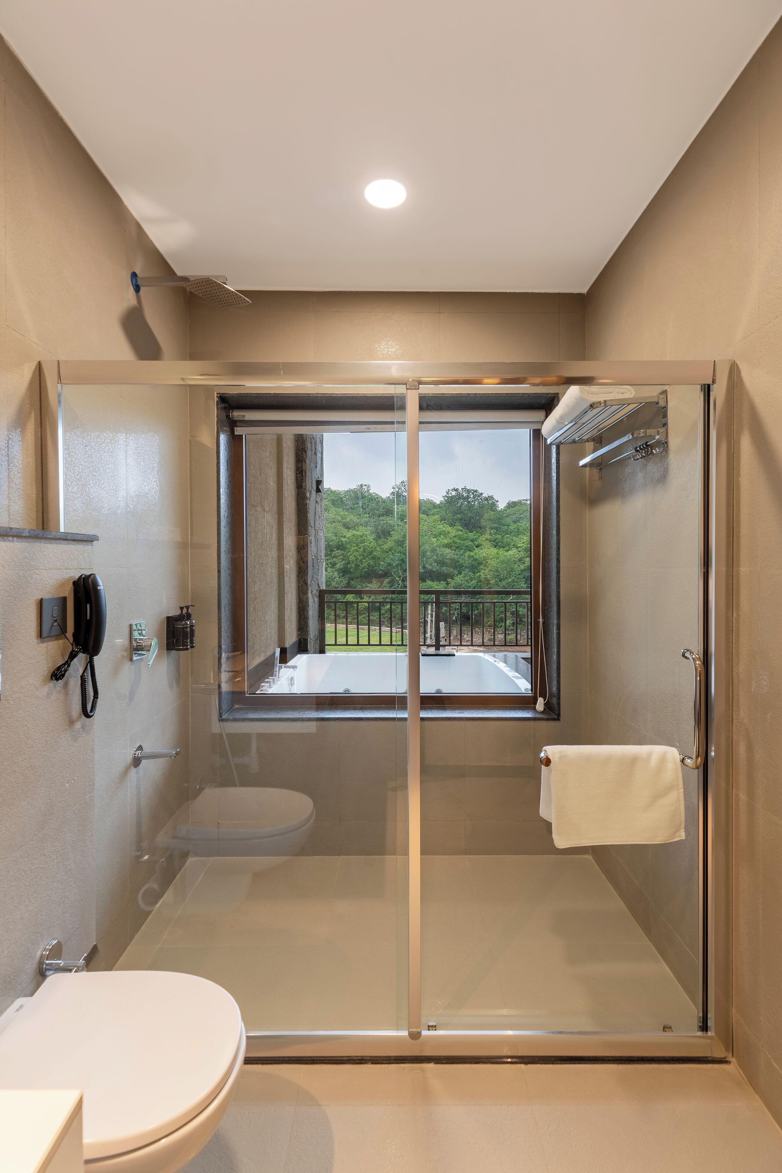 A modern bathroom with a glass-enclosed shower, a toilet, and a sink.
