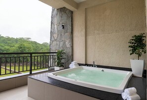 A bathroom with a large bathtub, a potted plant, and a view of greenery. - The Fort Resort by Namoka (Kumbhalgarh)