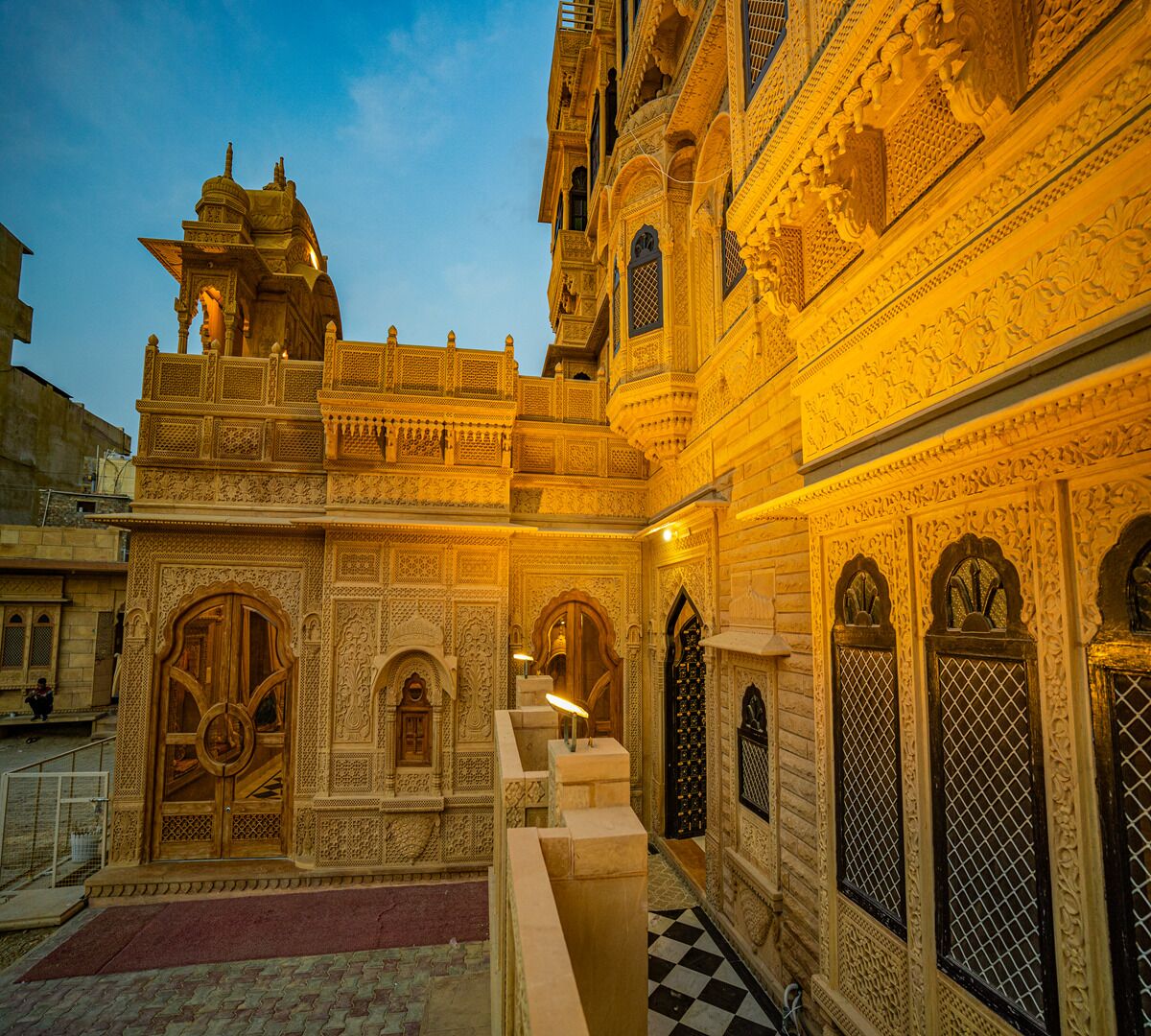 An intricately carved building with detailed architectural designs, including arched doorways and a central staircase.