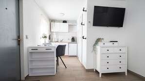 Una cocina moderna con armarios blancos, encimera negra y horno empotrado.