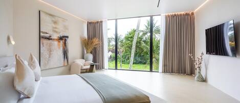 A modern bedroom with a large bed, a flat-screen TV, and a view of the outdoors.