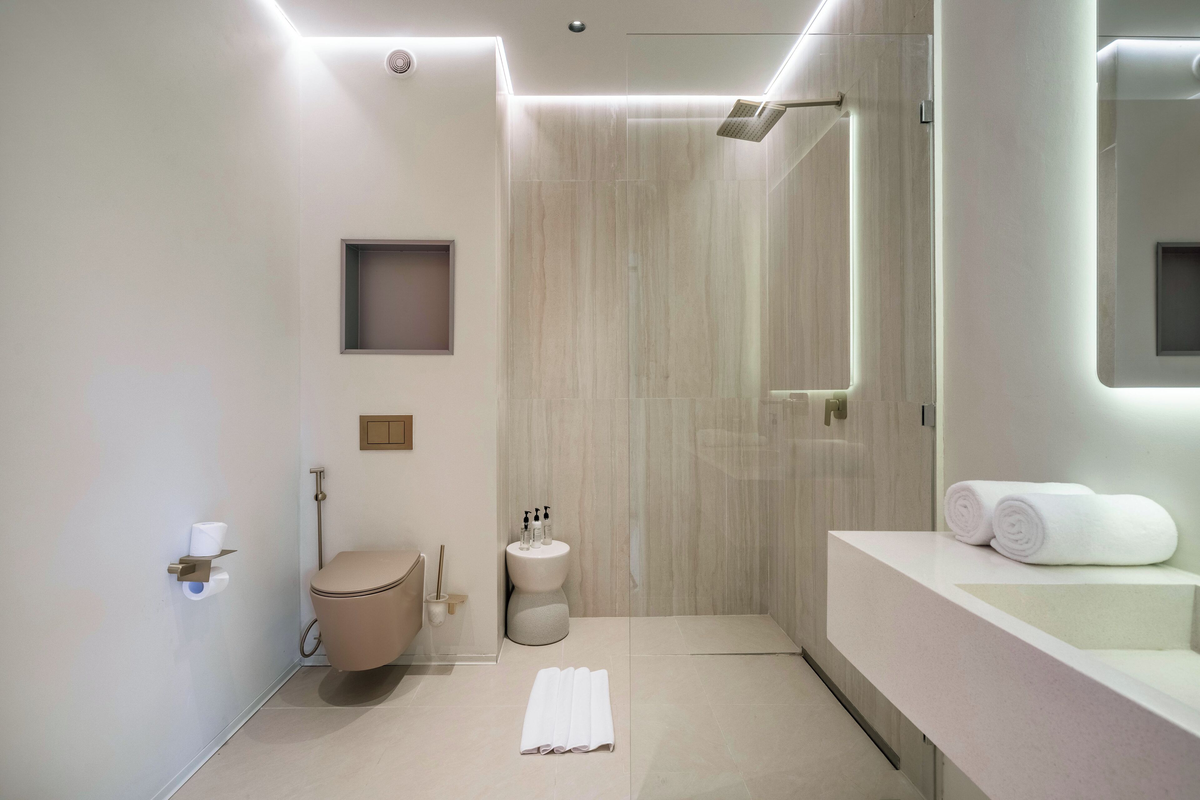 A modern bathroom with a toilet, bidet, and shower area.