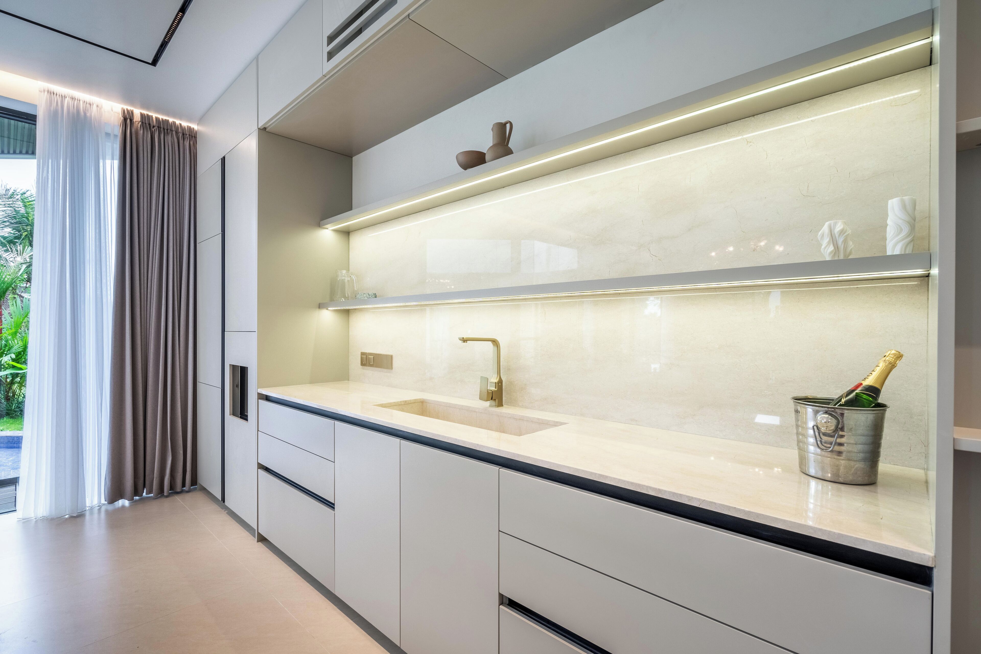 Una cocina moderna con una isla grande, un lavamanos empotrado y un cubo para vino.