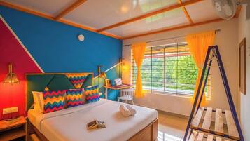 A bedroom with a bed, a desk, a chair, a ladder, and a window with curtains.