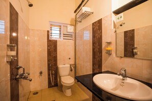 A bathroom with a toilet, sink, shower, and a window. - goSTOPS Coorg (Madikeri)