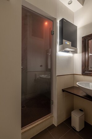 Une salle de bain moderne avec une douche à parois de verre, un lavabo blanc et un miroir au-dessus.