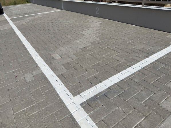 A paved area with a white line marking, possibly a parking or pedestrian zone.
