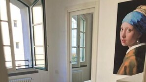A bedroom with a bed, a red pillow, and a painting on the wall. - Accomodo MIT51 Trivano Cenisio  (Milan)