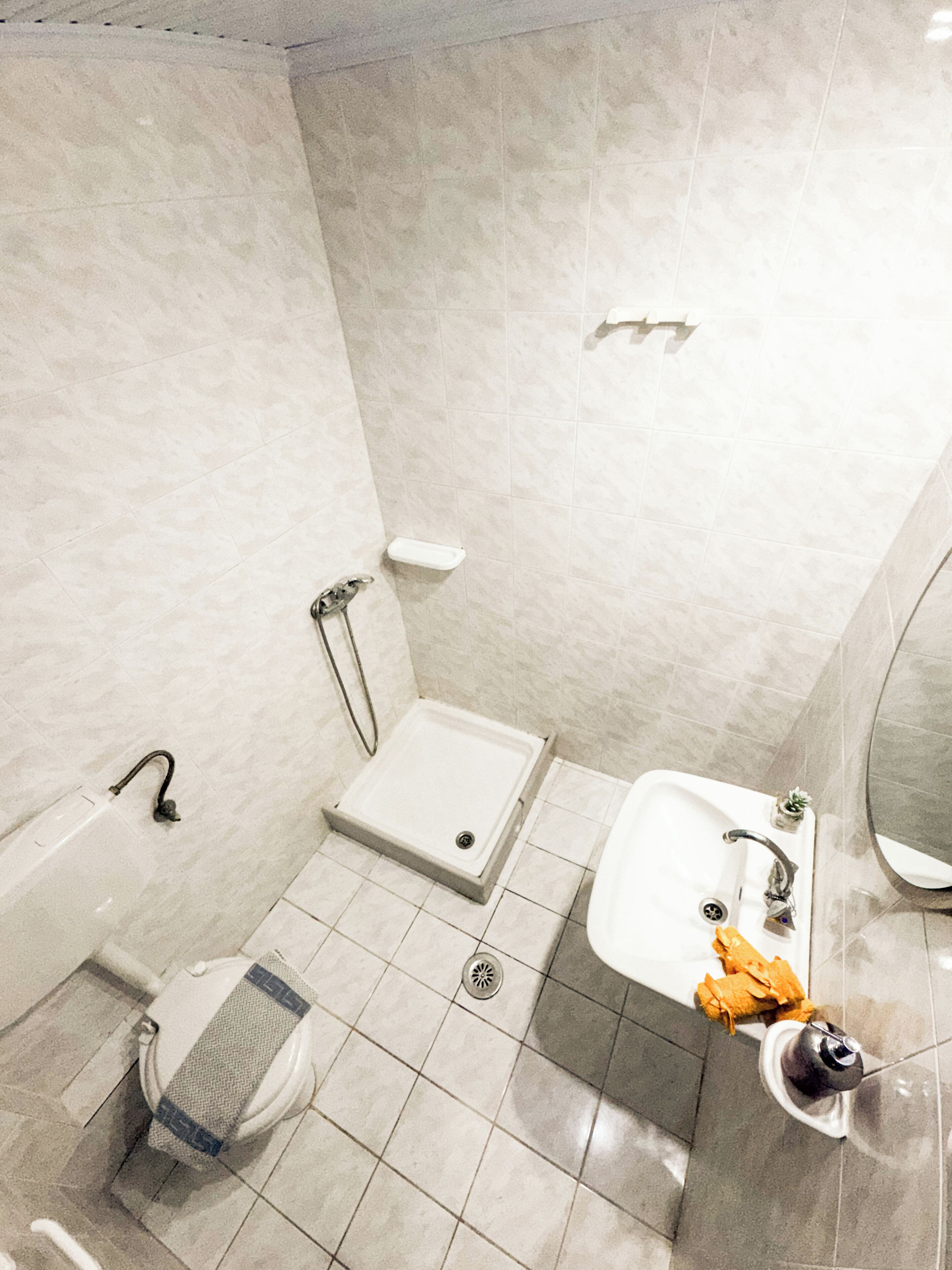 A bathroom with a shower, toilet, and sink.