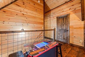 Un interior de madera con un jukebox, una puerta y un revestimiento de pared en cuadrícula.