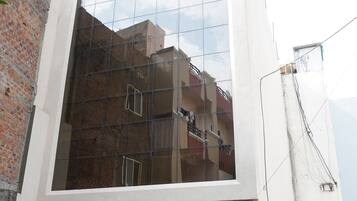 A modern building with a glass facade reflecting its surroundings.