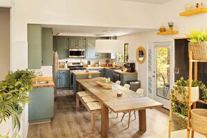 Una cocina moderna con una mesa de madera, un microondas y un fregadero.