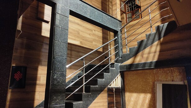 A staircase with a wooden interior and a metal railing. - The Premier Inn (Kolkata)