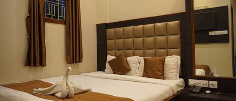 Quarto de hotel com uma cama grande, um telefone de apoio e um espelho na parede.