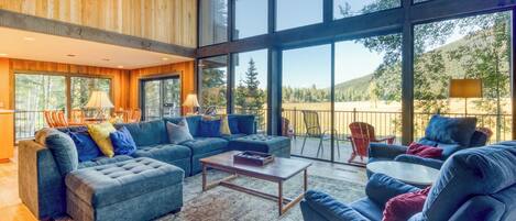 A spacious living area with a large window, a sofa set, and a coffee table.