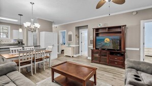 A spacious living room with a wooden coffee table, grey sofas, and a television on a wooden cabinet. - Myrtlewood Unit 103 - Golf Area! (Myrtle Beach)