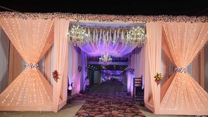 A grand entrance with draped curtains and floral decorations, leading to a well-lit interior. - Hotel Crown Resort (Satna)