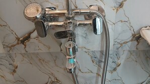 A shower with a handheld showerhead and a handheld shower attachment. - Awadh Biharee Inn (Faizabad)