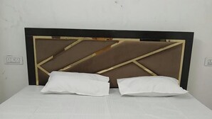 A bed with a wooden headboard and two pillows. - Awadh Biharee Inn (Faizabad)