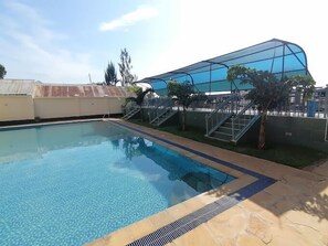 A swimming pool with a clear blue water surface, surrounded by a stone deck and metal railings. - Allaxis Hotel Migori (Migori)