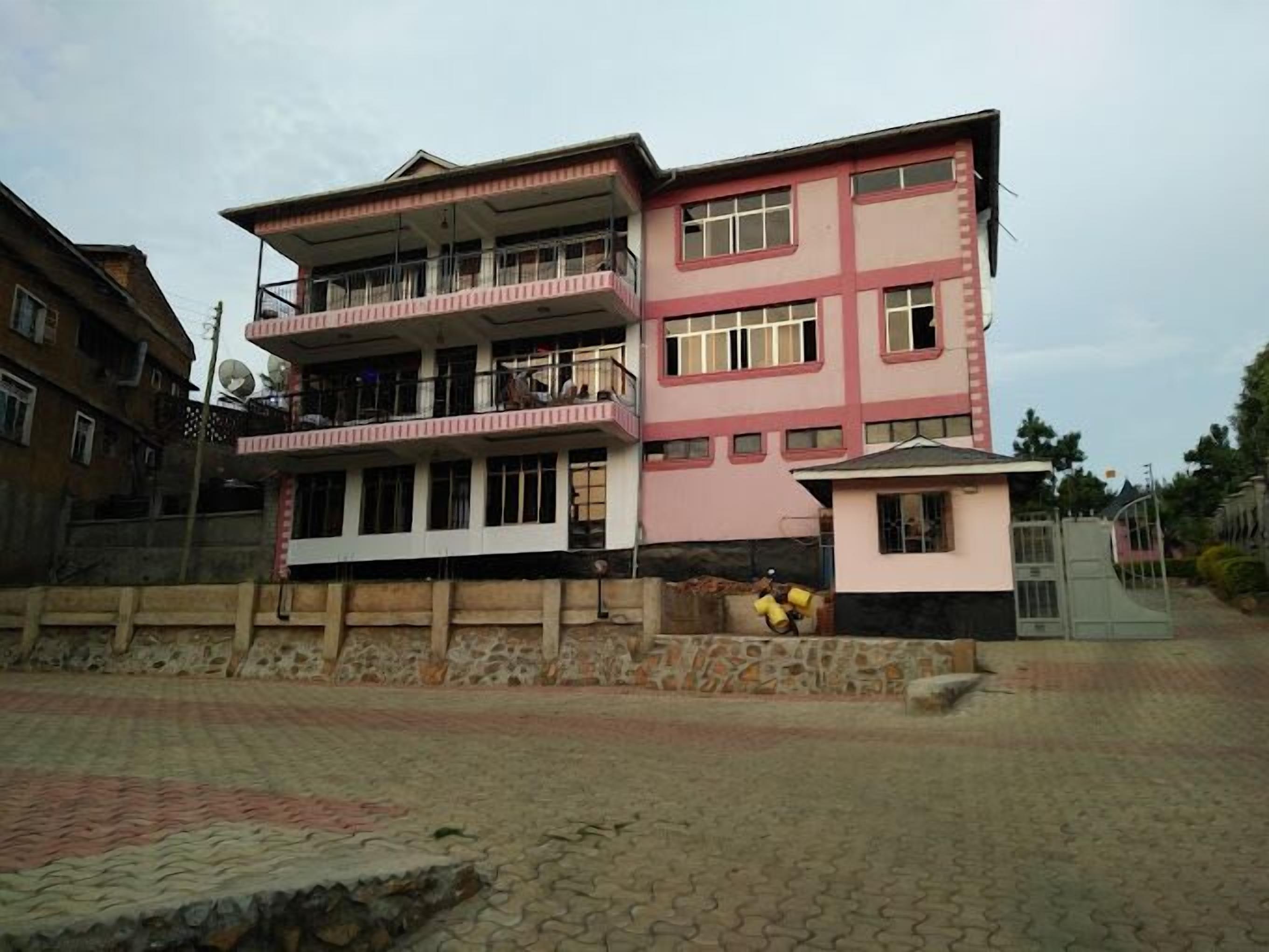 Um edifício com vários andares, varandas e uma pequena construção anexa.
