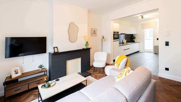 Un salon moderne doté d’un téléviseur à écran plat, d’une cheminée, d’un canapé et d’un coin repas.