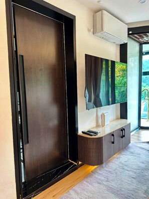 Un intérieur moderne avec une armoire en bois, un téléviseur fixé au mur et un meuble encastré.
