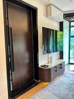Un interior moderno con un armario de madera, un televisor montado y un mueble empotrado.