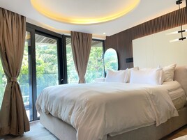Un dormitorio moderno con una cama grande, una lámpara de techo y vistas al exterior.