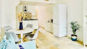 Un espacio habitable compacto con comedor, kitchenette y refrigerador.