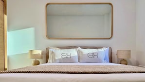 A neatly made bed with two pillows, a large mirror above, and two bedside lamps. - Canaryislandshost I Cactus II (Mala)