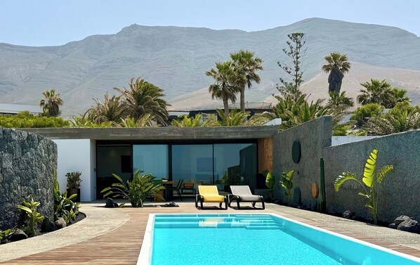 Un espace piscine moderne offrant une vue dégagée sur les montagnes en arrière-plan.