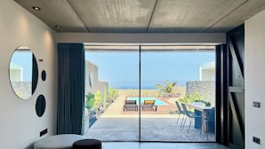 Una habitación de hotel moderna con un amplio ventanal corredero que da a una zona de piscina exterior.