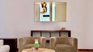 Una sala de estar moderna con dos sillones, una mesa redonda de madera y una lámpara decorativa.