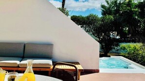 A patio area with a round table, chairs, and a hot tub. - Canaryislandshost l Las Palmeras (Nazaret)