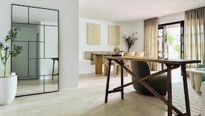 A modern living room with a dining area, a large mirror, and a potted plant. - Canaryislandshost l Las Palmeras (Nazaret)