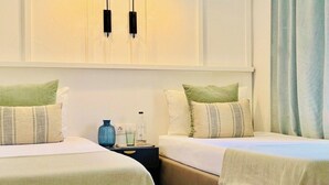 Een hotelkamer met twee bedden, een nachtkastje, een vaas en een lamp.